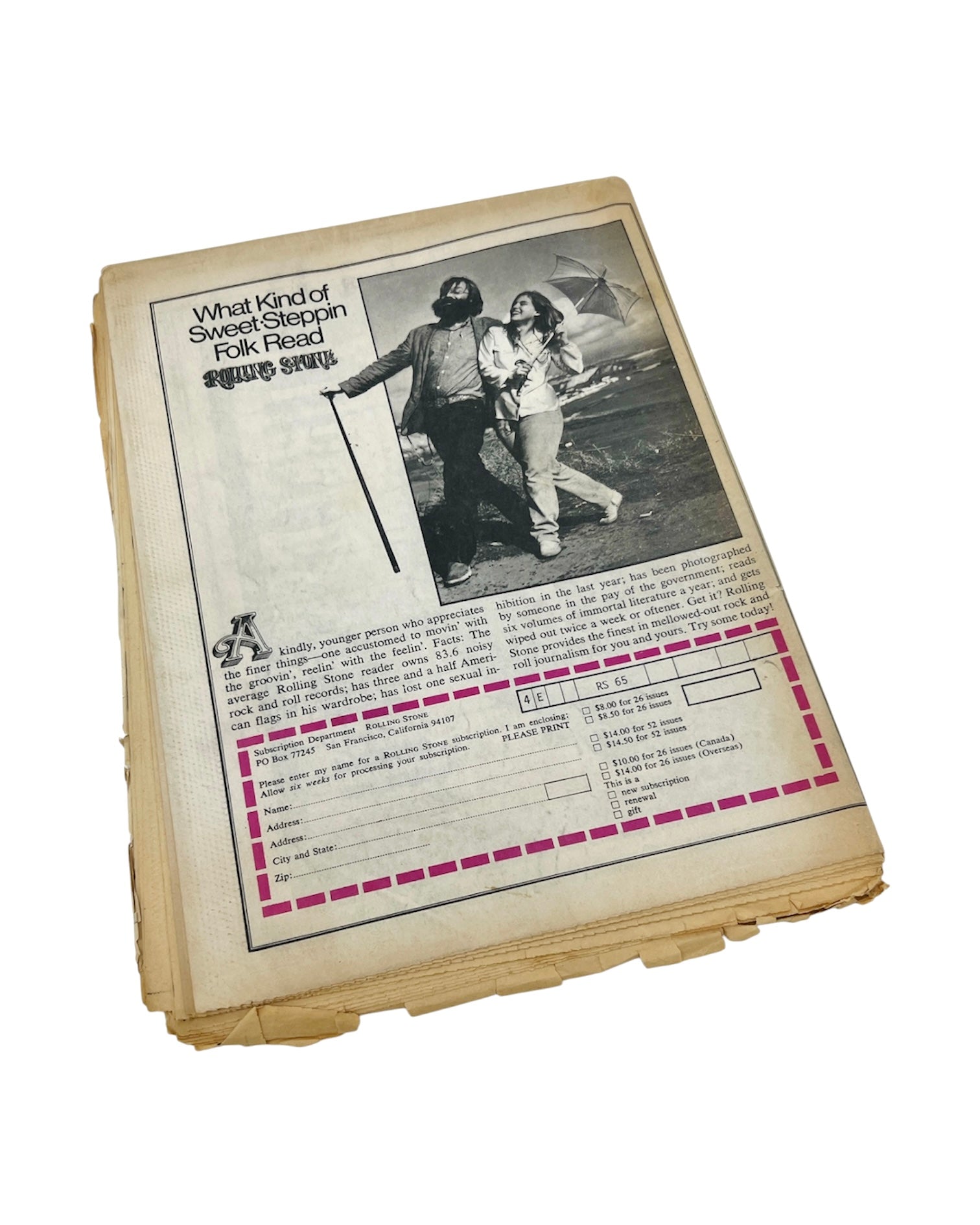 Th back of a 1970 vintage Rolling Stone magazine showing a black-and-white photo of two people outdoors, with printed text and a pink dashed border box near the bottom, photographed on a white background.